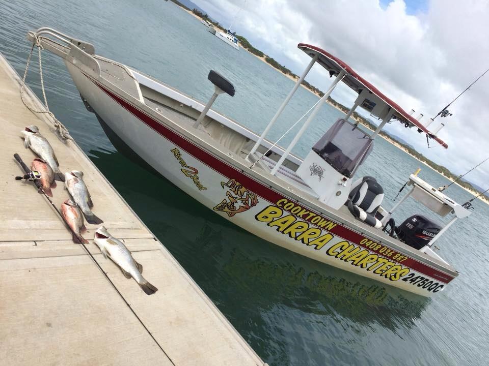 The old yellow Cooktown Barra Charters boat at the wharf